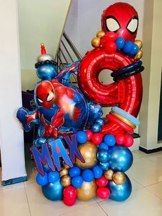 the balloon sculpture is made to look like spider - man and balloons are floating in the air