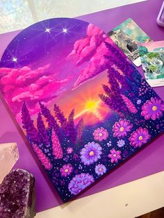 a painting on a table with some rocks and other items around it that include crystals