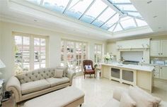 a living room filled with furniture and a skylight above the kitchen counter top area