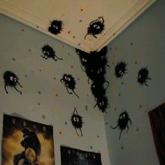 there are many pictures on the wall above the bed and below them is an upside down spider