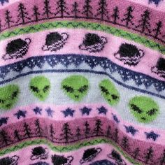 a knitted sweater with trees and elephants on the front in pink, blue, green and black