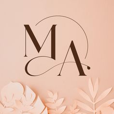 the letter m is made up of paper flowers and leaves on a pink background with an elegant monogram