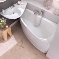 a white bath tub sitting next to a sink in a bathroom under a window with candles on it