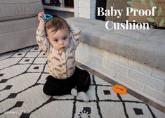 a baby sitting on the floor playing with a toy