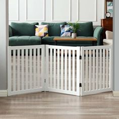 a living room with a couch, coffee table and two white gates that are open