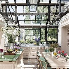 a kitchen filled with lots of green counter tops and wooden tables covered in flowers on top of them