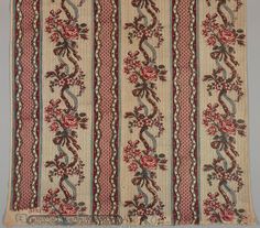 an old rug with flowers and vines on the side, in red and white stripes