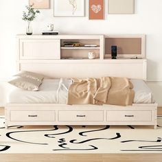 a white bed sitting in a bedroom on top of a hard wood floor