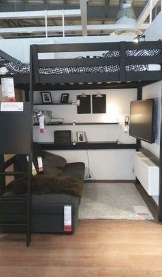 a loft bed is in the middle of a living room with a couch and television