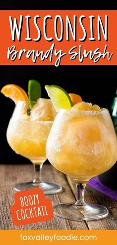 two glasses filled with orange and lime margarita cocktails on top of a wooden table