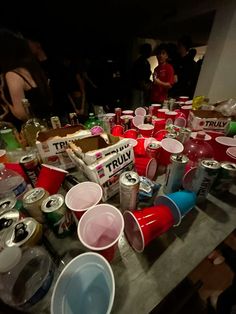 the table is full of empty cups and cans