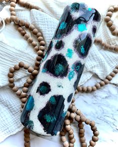 a black and white vase sitting on top of a wooden beaded necklace