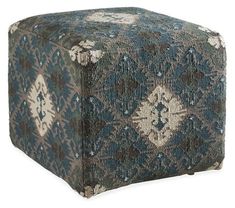 a blue and white ottoman with an intricate design on it's sides, sitting in front of a white background