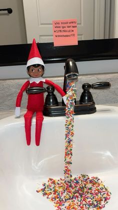 an elf is sitting in the sink with sprinkles