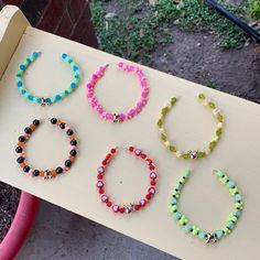 four different colored bracelets sitting on top of a bench