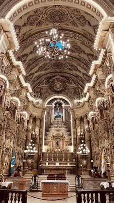 the inside of a church with chandeliers and pews