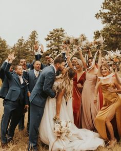 a group of people standing next to each other holding up their hands in the air