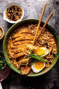 an overhead view of a bowl of ramen with chopsticks and eggs in it