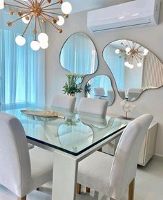 a dining room table with chairs and mirrors