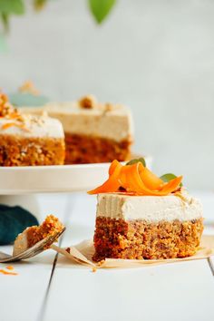 a slice of carrot cake with cream cheese frosting and orange zest on top