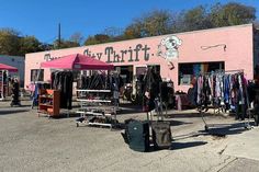 there is a pink building with clothes on display