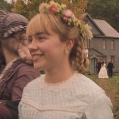 two women dressed in period clothing smile at the camera