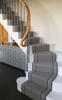 there is a stair case next to the stairs in this house with gray carpet and white walls