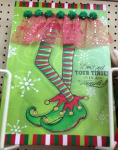 a christmas card with an elf's hat and stockings on it, in a store