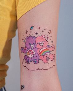 a woman's arm with a small tattoo of two teddy bears on top of a cloud