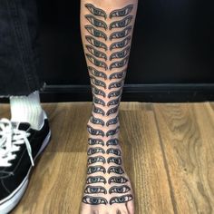 a person's foot with tattoos on it and their fingers in the shape of eyes