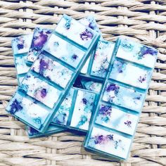 blue and purple soap bars sitting on top of a wicker basket