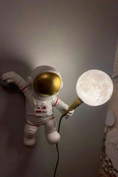 an astronaut is holding a lamp in his hand