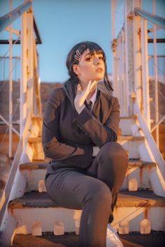 a woman sitting on some steps with her hand under her chin