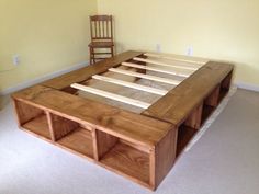 a wooden bed frame sitting in the middle of a room