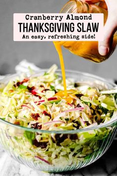 someone pouring dressing into a salad in a glass bowl