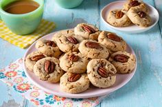 several pecan cookies on a plate next to a cup of coffee