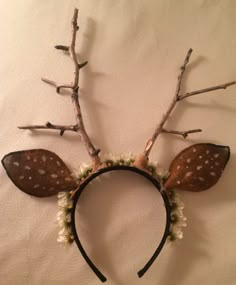 a deer headband with flowers and branches on it