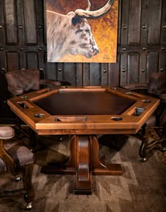 a wooden table with two chairs around it and a painting on the wall behind it