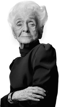 an older woman with white hair and wearing a green dress is posing for the camera