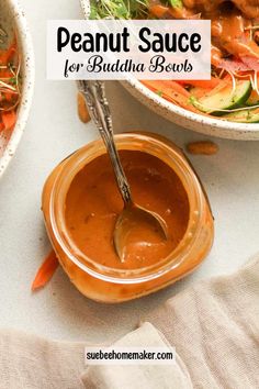 two bowls filled with peanut sauce next to a bowl of salad and a spoon in it