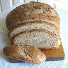 a loaf of bread sitting on top of a cutting board next to some slices of bread