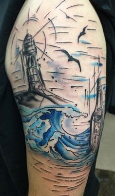 a man with a lighthouse tattoo on his arm