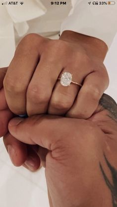 a person holding the hand of another person wearing a diamond ring