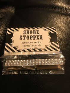 a pair of scissors sitting on top of a black leather chair next to a sign that says snobre stopper