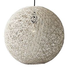 a large white ball hanging from a black wire hook on a string light fixture that is suspended in the air