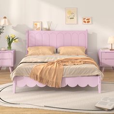 a pink bed sitting on top of a wooden floor next to two nightstands and a lamp