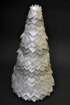 a white christmas tree made out of ruffles and lace on a black background