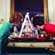 two women looking at a model of a building