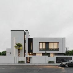 a modern house with palm trees and cars parked in front