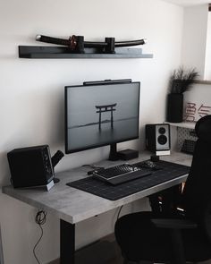 a desk with a computer and speakers on it